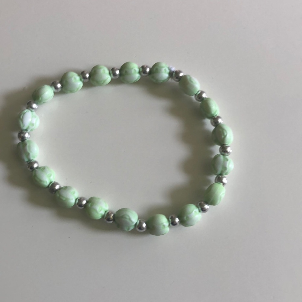 Green bracelet with monkey charms.